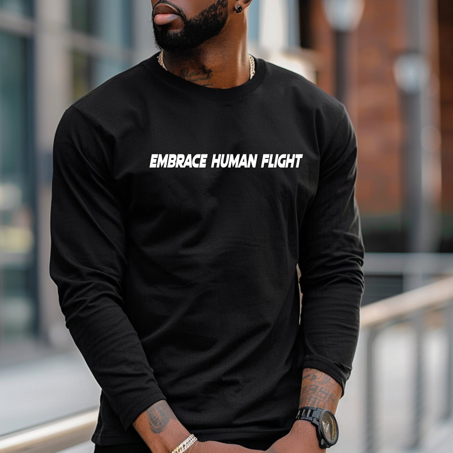 Person wearing a black long-sleeve shirt with 'EMBRACE HUMAN FLIGHT' text in an urban setting